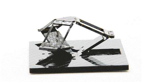 Image of a graspable haptic device, called Foldaway, that is the size of a drink coaster when flat, making it conveniently portable. The user places a joystick where the three hinged arms meet, and the arms offer resistance, to give a sense of the objects being manipulated.