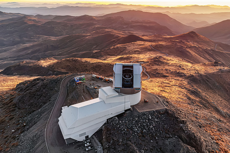 A large telescope sits on an arid mountaintop.