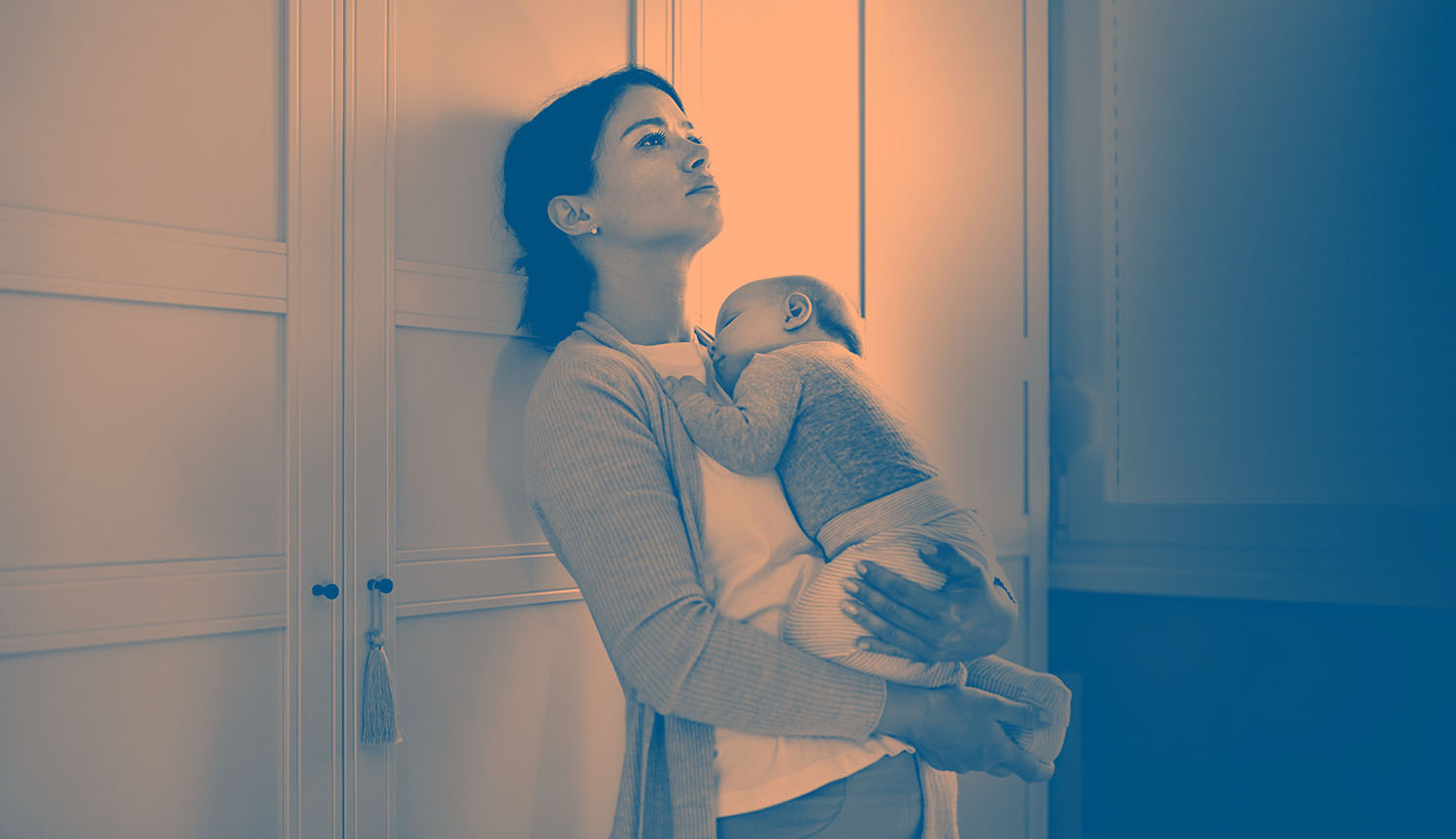 Photo, with shading, of a young woman holding an infant in her arms. She is leaning against the wall with a despairing look in her eyes.