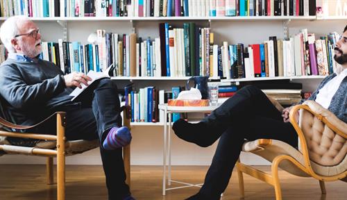 Photo shows a man sitting in psychotherapist’s office during a session.